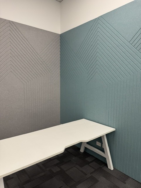 Blue and grey acoustic panels wrapping the walls of a meeting space